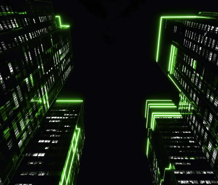 Torres de oficinas vistas desde abajo, de noche, con líneas de luz verde en sus bordes: caso de la web corporativa en WordPress de la fintech IRIS