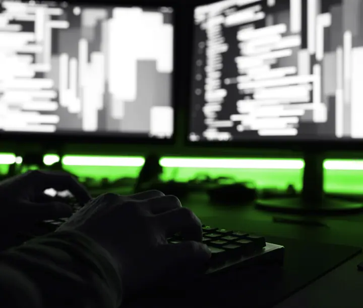 Two monitors showing a website's code in progress, the build stage when you outsource web development