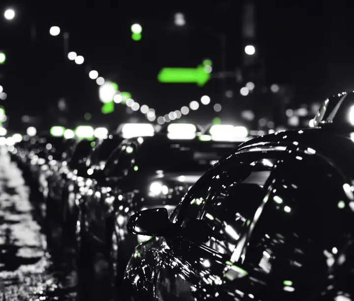 Fila de taxis estacionados en una avenida mojada de noche: caso del core de crédito SaaS a la medida de Starkapital